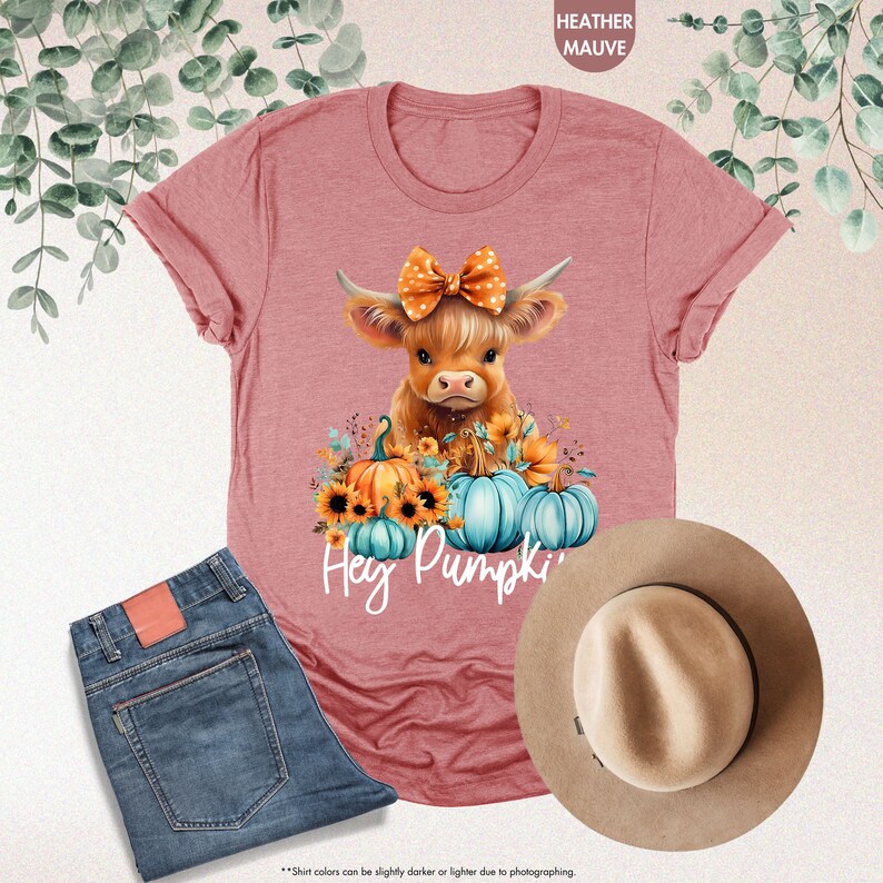 a pink shirt with a cow wearing a bow and pumpkins