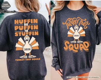 Puede incluir: Una sudadera de cuello redondo en gris jaspeado oscuro con estampados gráficos en naranja. La parte trasera muestra el texto "HUFFIN AND PUFFIN FOR STUFFIN" sobre una ilustración de un pavo con "2026" y "TURKEY TROT SQUAD". El frente muestra "Turkey Trot SQUAD".