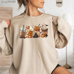 a woman is wearing a sweatshirt with a picture of pumpkins
