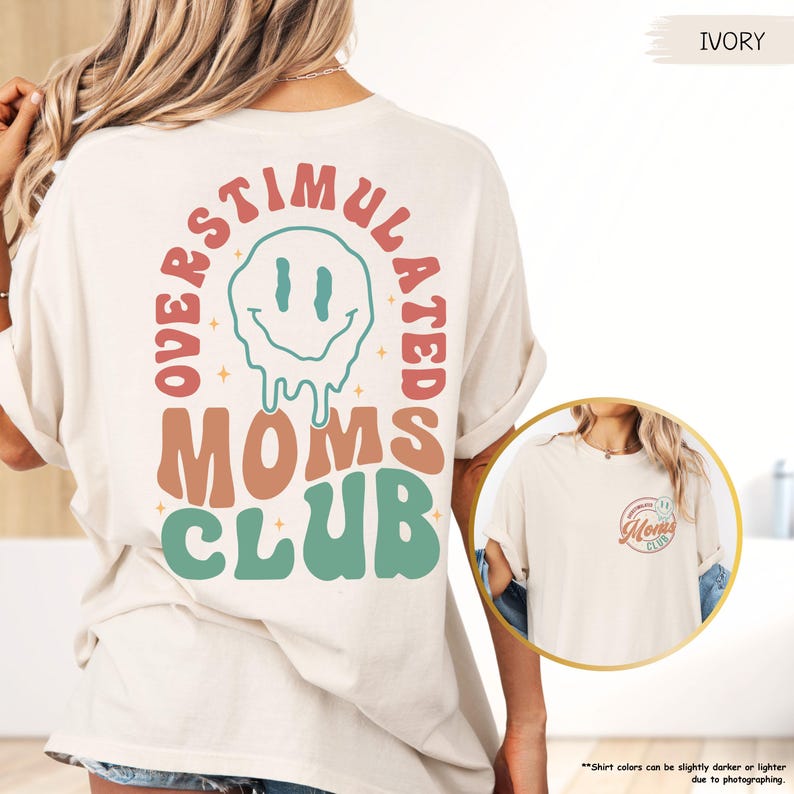 K&ouml;nnte beinhalten: Elfenbeinfarbenes T-Shirt mit dem Text "OVERSTIMULATED MOMS CLUB" in Retro-Schrift und einem schmelzenden Smiley-Gesicht. Das Shirt hat kurze &Auml;rmel und eine lockere Passform. Der Text "IVORY" befindet sich in der oberen rechten Ecke.