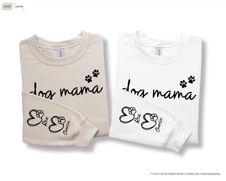 May include: Two long-sleeved sweatshirts, one sand-colored and one white, with the text "dog mama" in black script. Each shirt has paw prints and the names "Rex" and "Charlie" on the sleeve.