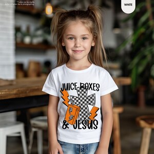 a young girl wearing a t - shirt with a cross on it
