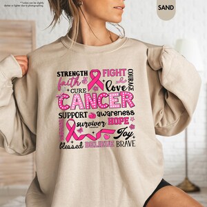 a woman wearing a sweatshirt with a pink ribbon on it