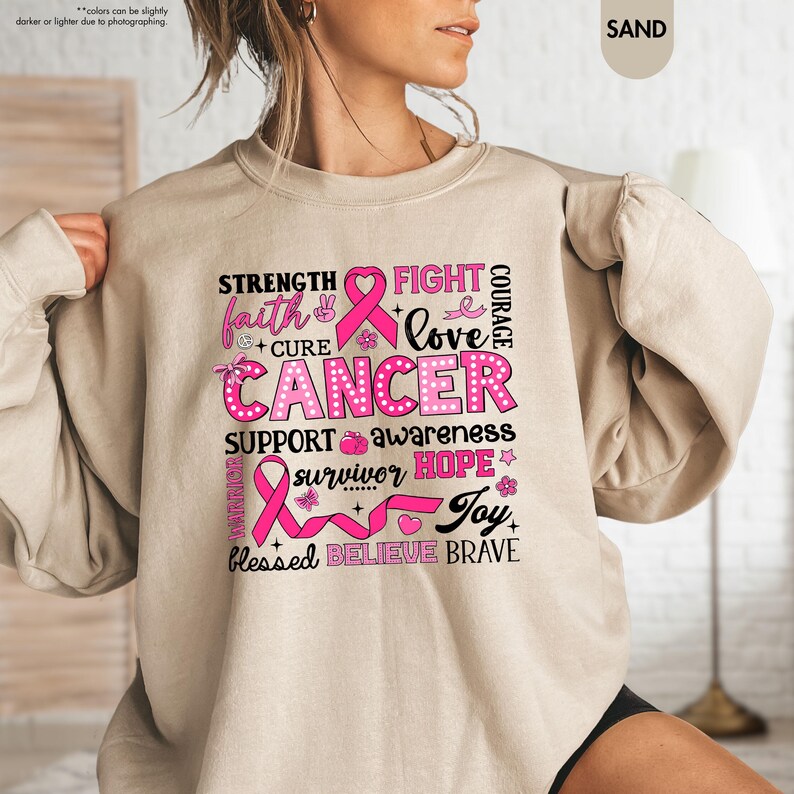 a woman wearing a sweatshirt with a pink ribbon on it
