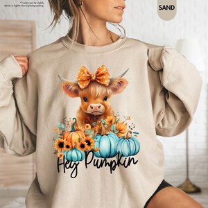 a woman wearing a sweatshirt with a cow on it