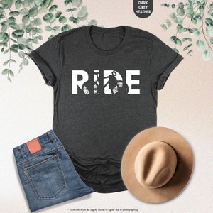 a t - shirt that says ride next to a hat and jeans