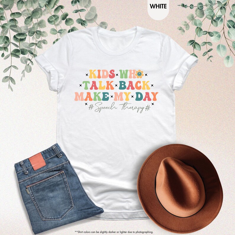 May include: White t-shirt with a colorful graphic that says "KIDS WHO TALK BACK MAKE MY DAY #Speech therapy#"