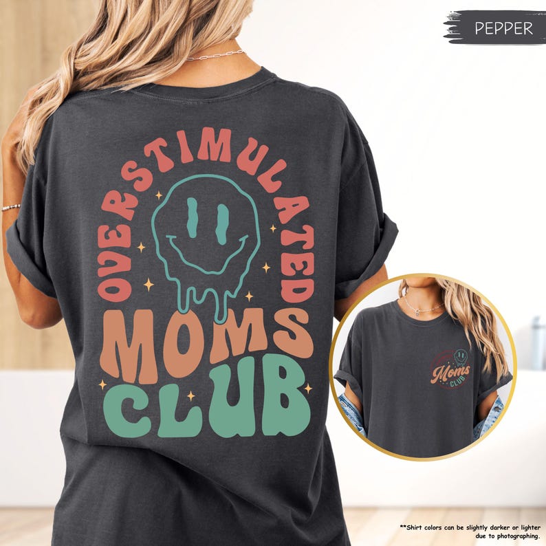K&ouml;nnte beinhalten: Dunkelgraues T-Shirt mit dem Schriftzug "OVERSTIMULATED MOMS CLUB" in einem Retro-Design. Das Design beinhaltet ein schmelzendes Smiley-Gesicht und Sterne. Das Shirt hat die Farbe Pfeffer.