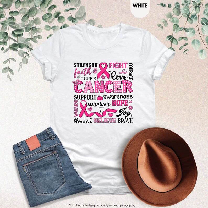 a t - shirt with a pink ribbon and a hat next to it
