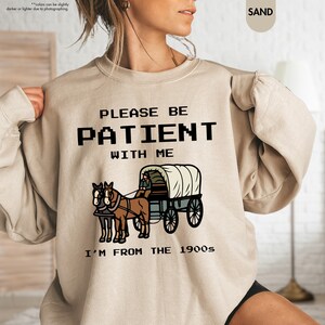 a woman wearing a sweatshirt that says please be patient with me i'm from