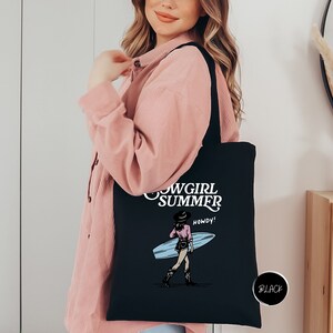 a woman holding a black tote bag with a picture of a girl holding a
