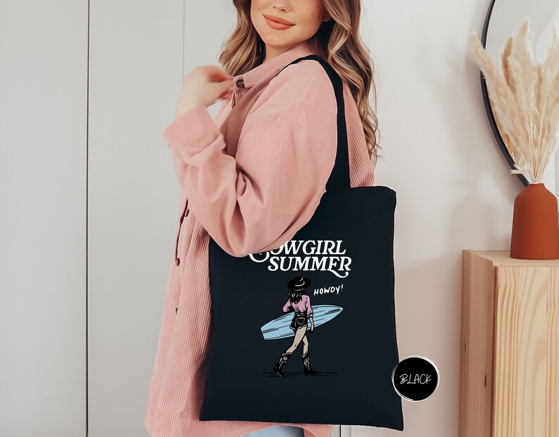 a woman holding a black tote bag with a picture of a girl holding a