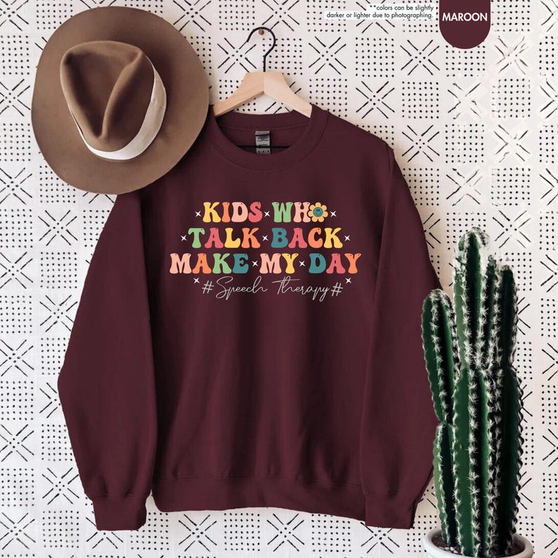 May include: Maroon sweatshirt with the text "KIDS WHO TALK BACK MAKE MY DAY #Speech therapy#" in colorful letters with flower accents.