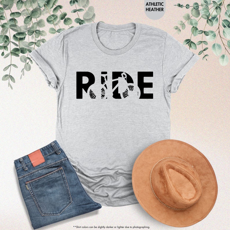 a t - shirt that says ride next to a hat and jeans