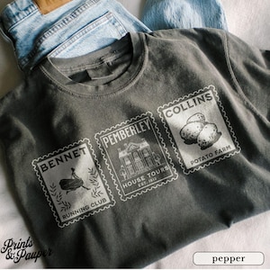K&ouml;nnte beinhalten: Pfefferfarbenes T-Shirt mit drei Briefmarken-Grafiken. Die Grafiken enthalten die W&ouml;rter "BENNET RUNNING CLUB", "PEMBERLEY HOUSE TOURS EST. 1813" und "COLLINS POTATO FARM". Das Shirt wird mit hellblauen Jeans kombiniert.