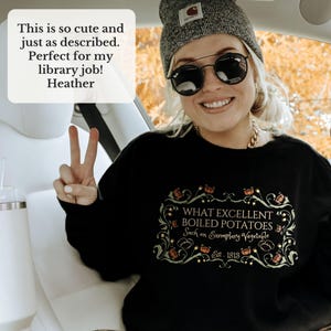 Puede incluir: Una sudadera negra con el texto "WHAT EXCELLENT BOILED POTATOES Such an Exemplary Vegetable Est. 1813" en un marco decorativo. La sudadera la lleva una persona con un gorro gris y gafas de sol.