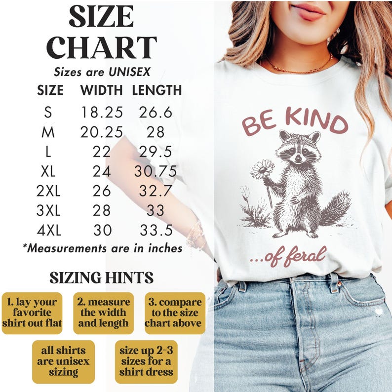 May include: White t-shirt with a black and white illustration of a raccoon holding a flower. The text "Be Kind...of feral" is printed in pink on the shirt. A size chart is included with width and length measurements in inches.