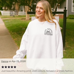 Puede incluir: Sudadera blanca con un gr&aacute;fico en blanco y negro en el pecho superior. El gr&aacute;fico incluye una calavera y el texto "DARK ROMANCE" y "WORLD TOUR DE FORCED". La sudadera es de manga larga.