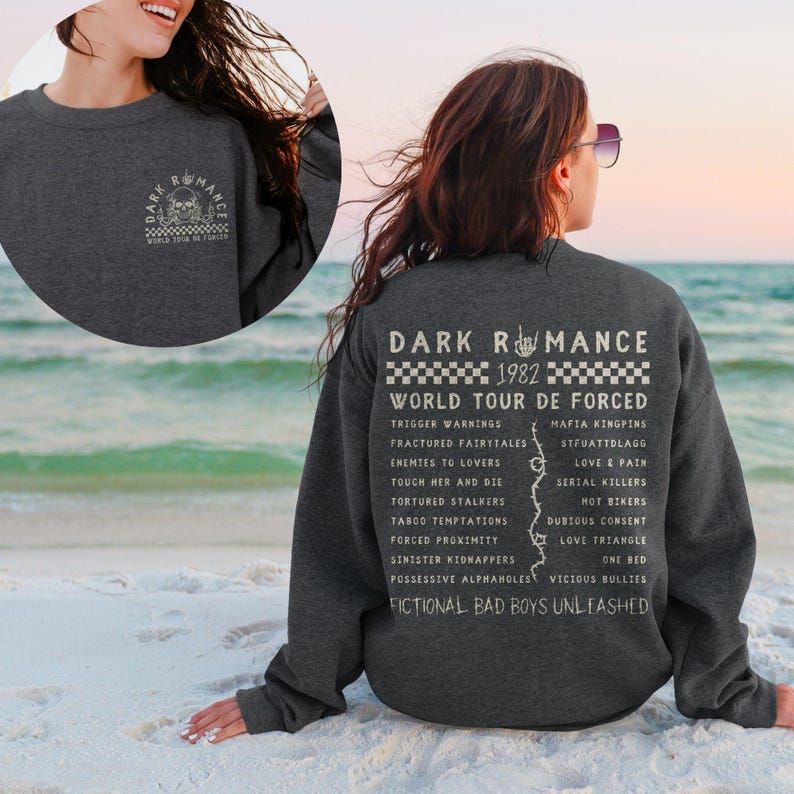 Puede incluir: Sudadera gris oscuro con un gr&aacute;fico en la parte delantera y trasera. El gr&aacute;fico frontal presenta una calavera y las palabras "Dark Romance World Tour De Forced". El gr&aacute;fico trasero enumera las fechas de la gira y los t&iacute;tulos de las canciones.