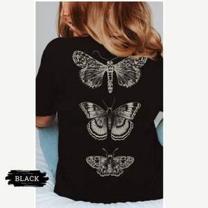 K&ouml;nnte beinhalten: Schwarzes T-Shirt mit drei verschiedenen Schmetterlingsmotiven auf der R&uuml;ckseite. Die Schmetterlinge sind vertikal angeordnet, wobei der gr&ouml;&szlig;te Schmetterling oben und der kleinste unten ist.