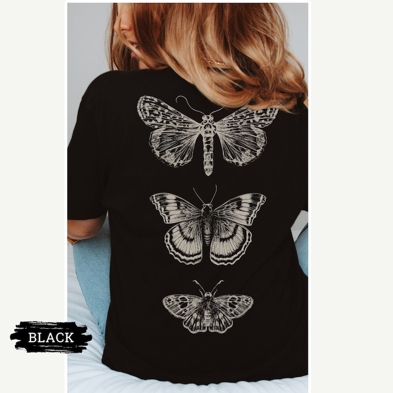K&ouml;nnte beinhalten: Schwarzes T-Shirt mit drei verschiedenen Schmetterlingsmotiven auf der R&uuml;ckseite. Die Schmetterlinge sind vertikal angeordnet, wobei der gr&ouml;&szlig;te Schmetterling oben und der kleinste unten ist.