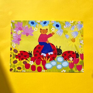 May include: A whimsical illustration featuring a tiger-like character riding a ladybug. The scene is filled with colorful flowers, including sunflowers, tulips, and daisies, set against a yellow background. Three ladybugs are present in the image.