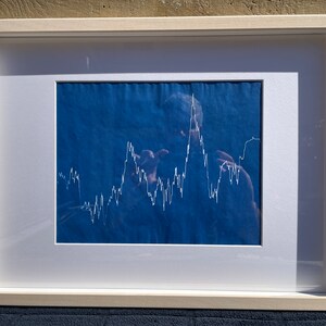 Puede incluir: Un dibujo de línea blanca de una ciudad sobre un fondo azul, enmarcado en un marco blanco.