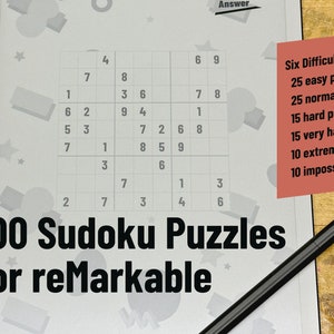 May include: A close-up of a white tablet with a Sudoku puzzle on the screen. The tablet is on a wooden surface with a black stylus next to it. The text "100 Sudoku Puzzles for reMarkable" is printed on the screen. A red sticky note with the text "Six Difficulty Levels: 25 easy puzzles, 25 normal puzzles, 15 hard puzzles, 15 very hard puzzles, 10 extreme puzzles, 10 impossible puzzles" is on the right side of the screen.