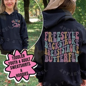 Peut inclure: Un sweat-shirt à capuche noir avec un motif sur le devant portant le nom Olivia et une icône de nageur. Le dos présente un texte ondulé et coloré indiquant Freestyle, Backstroke, Breaststroke et Butterfly, agrémenté de petites étoiles.