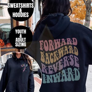 May include: Black hoodie with the words "FORWARD BACKWARD REVERSE INWARD" in a retro font on the back. The hoodie also has the word "LILY" and a lightning bolt design on the front. The image also shows "SWEATSHIRTS & HOODIES" and "YOUTH & ADULT SIZING".