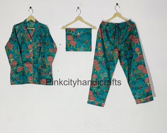 May include: A teal blue pyjama set with a floral print featuring birds. The set includes a long-sleeved shirt with a button-up front and matching trousers.