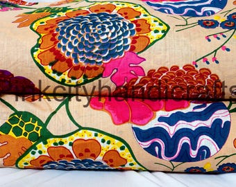May include: Beige fabric with a colorful floral print. The fabric features large flowers with orange, red, pink, blue, and green accents. The fabric is perfect for crafting projects, quilting, and home decor.