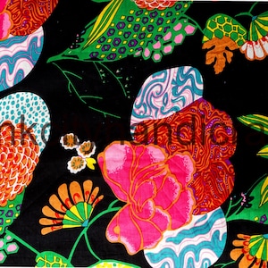 May include: Black fabric with a colorful floral pattern. The flowers are pink, orange, green, and blue. The fabric has a retro, psychedelic style.