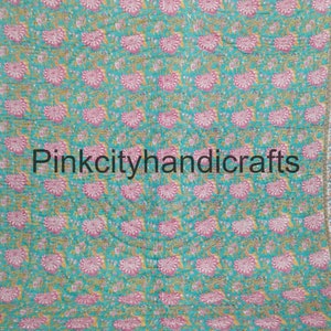 Puede incluir: Una colcha de color azul turquesa y rosa con estampado floral y el texto "Pinkcityhandicrafts" en el centro.