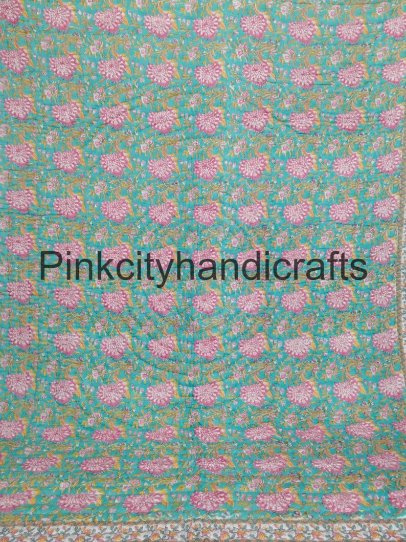 Puede incluir: Una colcha de color azul turquesa y rosa con estampado floral y el texto "Pinkcityhandicrafts" en el centro.