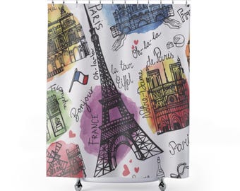 May include: A white shower curtain with a colorful watercolor pattern featuring iconic Parisian landmarks, including the Eiffel Tower, Notre Dame Cathedral, and the Arc de Triomphe. The text "Oh-la-la", "la tour Eiffel", "Bonjour", and "France" is written on the curtain.