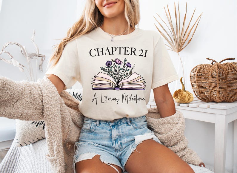 a woman wearing a t - shirt with a book and flowers on it