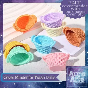 May include: A collection of miniature basket-shaped cover minders in various colors including orange, lavender, cream, brown, yellow, light blue, mint green, and pink. Each small basket features a woven texture and two side handles.