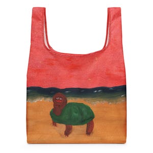 May include: A red reusable shopping bag featuring a whimsical painting of a turtle on a beach. The turtle has a green shell and is standing on a sandy shore with a red sky and ocean waves in the background.