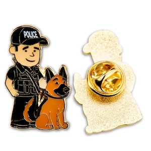 Peut inclure: Épinglette en métal doré représentant un policier de dessin animé avec un berger allemand. Le policier porte un uniforme noir avec un badge sur lequel est inscrit "POLICE".