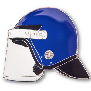 Pode incluir: Um capacete de polícia azul e preto com uma viseira transparente. O capacete tem um acabamento prateado e uma aba preta.