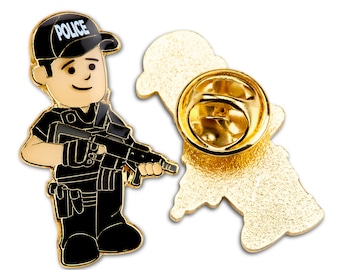May include: Gold-tone enamel pin featuring a cartoon police officer holding a gun. The pin says "Police" on the officer's hat. The back of the pin has a standard pin back.