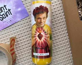 Puede incluir: Una vela amarilla con una imagen de un hombre con una corona de espinas y un corazón rojo. El texto en la vela dice "Just One More Thing."