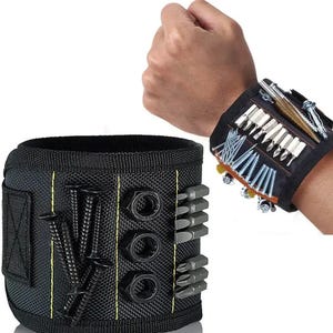 May include: A black magnetic wristband with a yellow stripe and multiple slots for holding screws, nails, and other small tools. The wristband is worn on a person's wrist.
