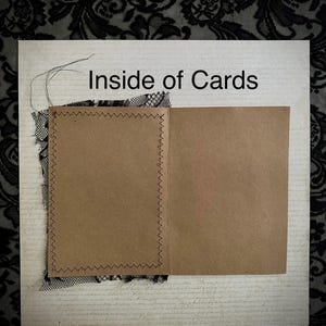 May include: An open greeting card with the text "Inside of Cards" is displayed. The card is made of brown paper and has a stitched border. Black lace and a patterned background are also visible.