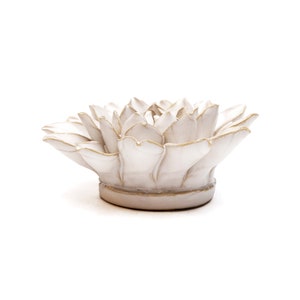 May include: A white ceramic lotus flower sculpture with gold trim. The flower has multiple petals and sits on a round base. The sculpture is a decorative item.