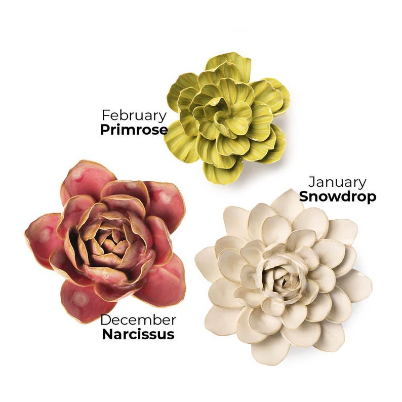 Pode incluir: Tr&ecirc;s esculturas de flores de cer&acirc;mica em tons de verde, creme e castanho-avermelhado. As flores s&atilde;o rotuladas como "Fevereiro Pr&iacute;mula", "Janeiro Galanto" e "Dezembro Narciso". As flores t&ecirc;m desenhos detalhados de p&eacute;talas.