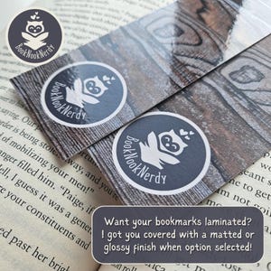 Peut inclure: Deux marque-pages rectangulaires avec un motif de grain de bois brun fonc&eacute;. Chaque marque-page pr&eacute;sente un logo circulaire avec un graphique de hibou blanc et le texte BookNookNerdy. Le texte sur l'image indique : Want your bookmarks laminated? I got you covered with a matted or glossy finish when option selected!