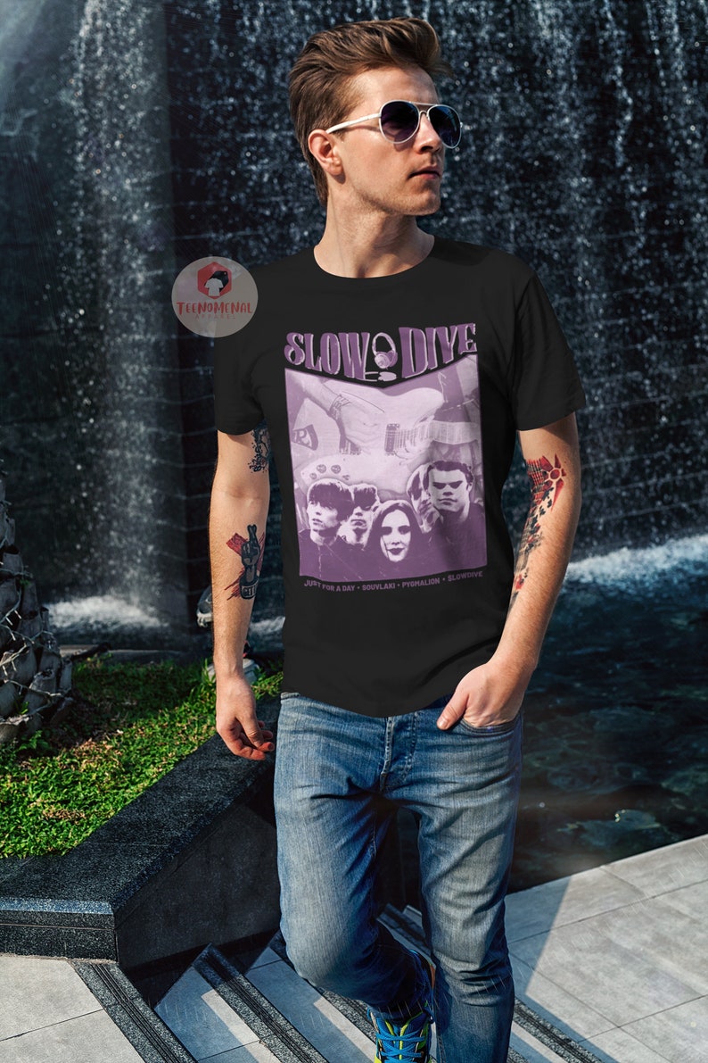 May include: A black t-shirt featuring a purple graphic of the band Slowdive. The graphic includes the band members and the text "Slowdive" in a purple circle. The text "Just for a Day - Souvlaki - Pygmalion - Slowdive" is printed below the graphic.
