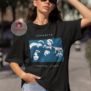 Puede incluir: Camiseta negra con un gr&aacute;fico blanco de la banda Slowdive. El gr&aacute;fico incluye una foto de los miembros de la banda y el texto "souvlaki (1993)".
